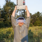 A man pouring a bucket of ice water over his head