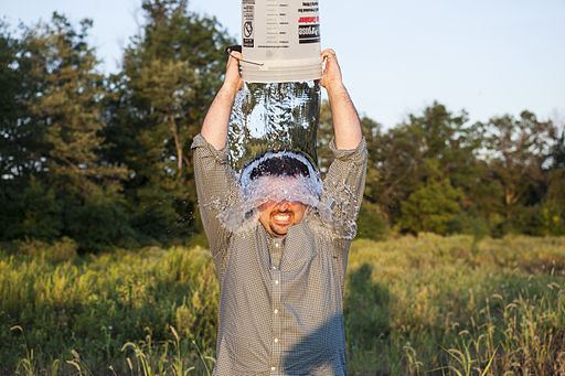 A man pouring a bucket of ice water over his head